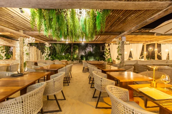 Allée du restaurant Preabeach sur le sable, sous un plafond végétalisé suspendu et des arches fleuries blanches
