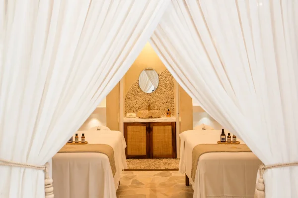 Cabine de massage en duo du spa Preabeach, deux tables de soin sous rideaux blancs