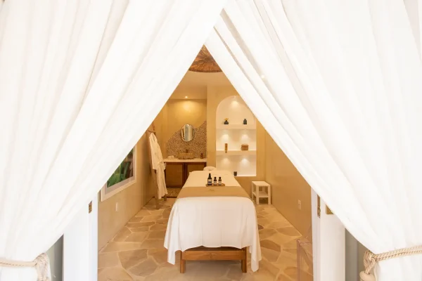 Cabine de massage individuelle du spa Preabeach, rideaux blancs et coin lavabo en pierre