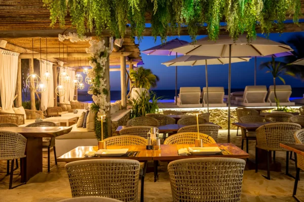 Restaurant de plage Preabeach avec tables en bois dressées, chaises tressées et parasols