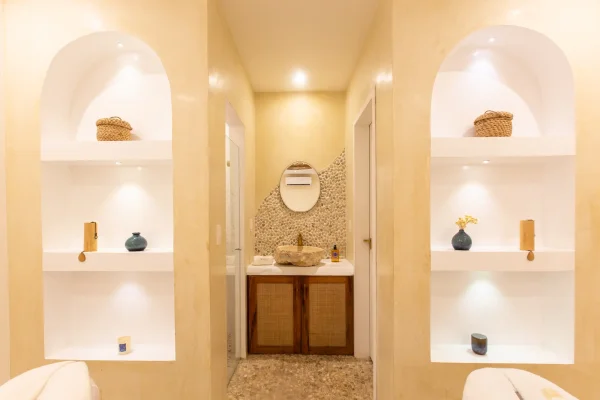  Salle de bain du spa Preabeach avec niches décoratives, vasque en pierre et miroir ovale